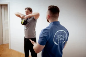 Medizinisches Rückentraining in Dresden: Personal Trainer Richard Proch korrigiert die Übungsausführung für schmerzfreie Bewegung